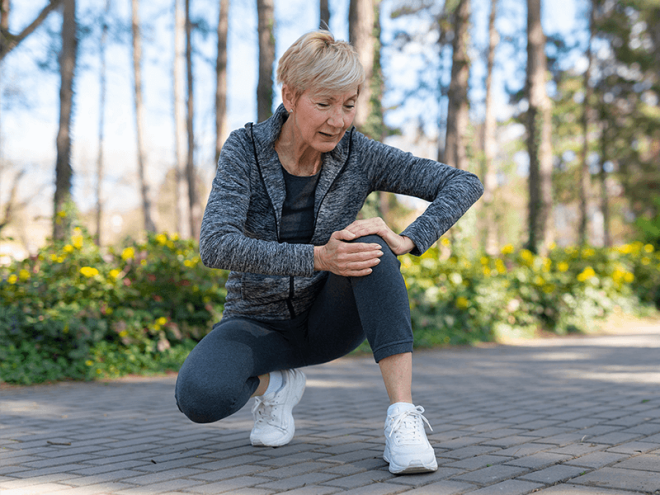 Woman holding knee with joint degeneration